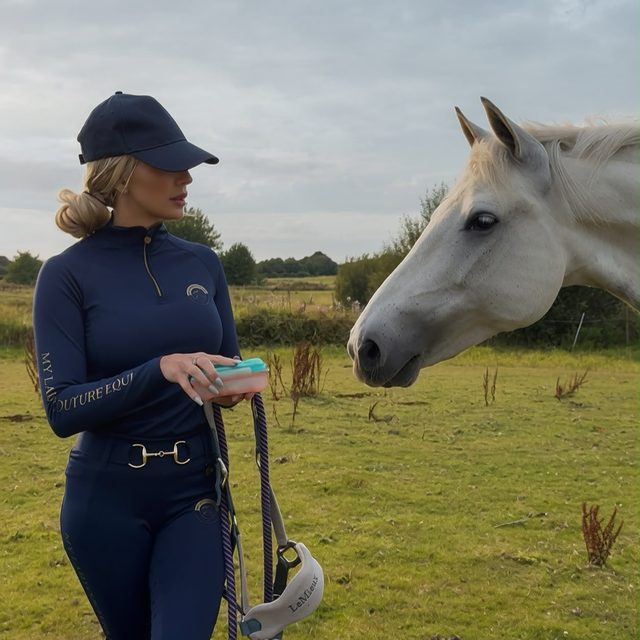Rider in the navy My Lady set walking with a white horse